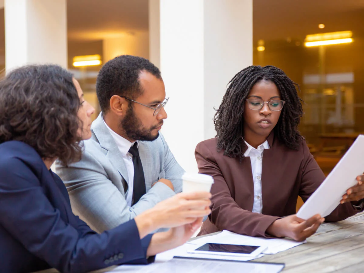 Couple consulting a lawyer about homestead exemption options, reviewing important legal documents at an outdoor office setting