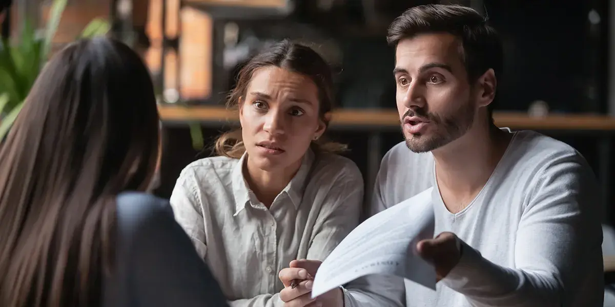 Sibling arguing about living in deceased parents house (1) picture of siblings arguing about one of them living in their deceased parents house rent free, all three of them sitting in the kitchen table, brother flashing document to sister sitting across from him
