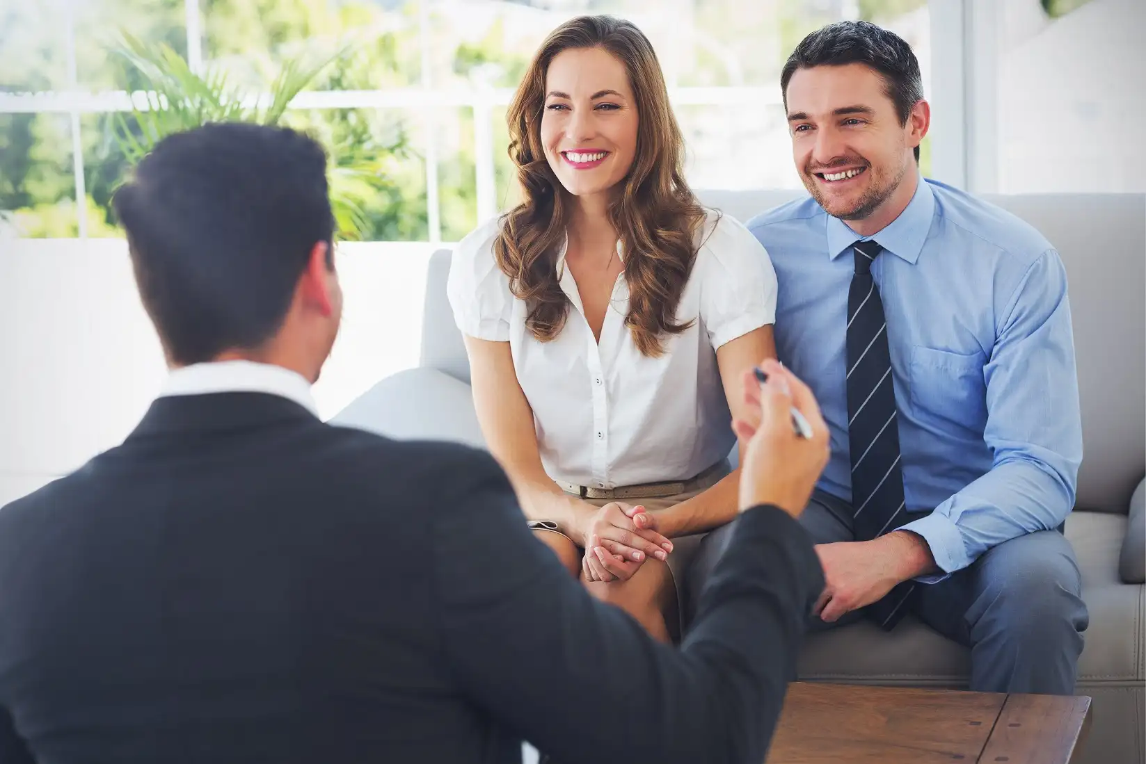 how to pick a good real estate agent interview Smiling couple meeting with a real estate agent for the first time to discuss how to pick a good real estate agent when selling their home, highlighting the importance of asking the right interview questions.