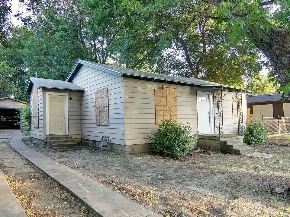 Selling a House in Poor Condition in henderson Distressed house in Henderson, NV with boarded-up windows, peeling exterior paint, and overgrown landscaping — example of a property in poor condition