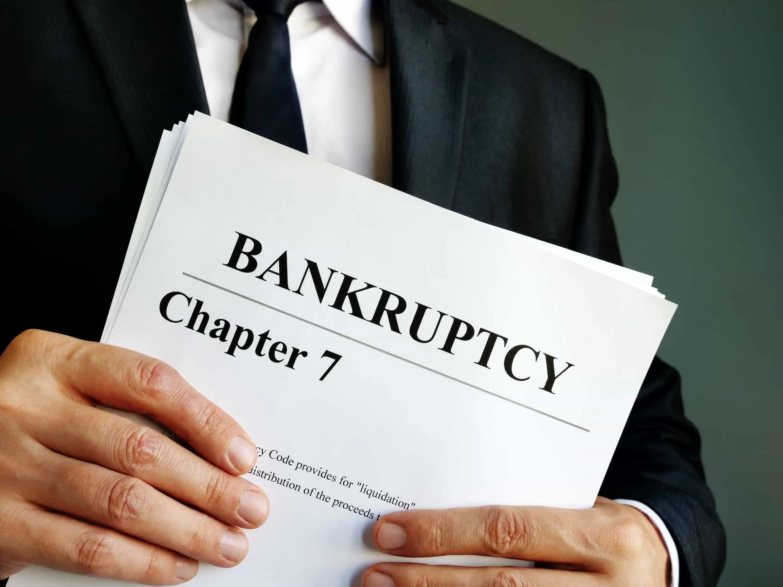 Close-up of Chapter 7 bankruptcy paperwork, held by an attorney in a suit, illustrating the process of selling a house after Chapter 7 bankruptcy